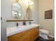 Modern bathroom with double sinks, wood cabinets, stylish mirrors, and a sleek design at 10639 Secret Garden Ln, Charlotte, NC 28214