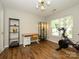 Versatile office/bedroom space with hardwood flooring, ample natural light, and a Peloton exercise bike at 10639 Secret Garden Ln, Charlotte, NC 28214