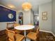 Stylish dining room with modern lighting, hardwood floors, and seamless transition to kitchen and living areas at 10639 Secret Garden Ln, Charlotte, NC 28214