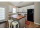 Modern kitchen featuring white cabinets, butcher block countertop, stainless appliances, and breakfast bar seating at 10639 Secret Garden Ln, Charlotte, NC 28214