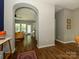 Open-concept view into living room with hardwood floors, arched entryway, and comfortable seating at 10639 Secret Garden Ln, Charlotte, NC 28214
