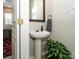 Stylish powder room featuring a pedestal sink and elegant decorative touches, with plants, and modern fixtures at 10639 Secret Garden Ln, Charlotte, NC 28214