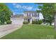 Traditional home with a lush front lawn, attached garage, and mature trees at 1111 Balcorn Pl, Charlotte, NC 28214