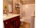 Cozy bathroom with cherry vanity, white countertops, and a shower-tub combination for relaxation at 11867 Ridgeway Park Dr, Charlotte, NC 28277