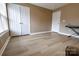 Bright bedroom featuring wood-look floors, a large window, and ample closet space for storage at 11867 Ridgeway Park Dr, Charlotte, NC 28277