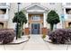 Inviting condo entrance featuring brick accents, manicured landscaping and visible unit addresses at 11867 Ridgeway Park Dr, Charlotte, NC 28277
