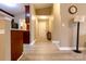 Bright hallway featuring wood-look floors, neutral walls, and a view to the front door and kitchen at 11867 Ridgeway Park Dr, Charlotte, NC 28277