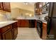 Open kitchen with sleek black appliances, dark wood cabinets, and an eat-in bar area at 11867 Ridgeway Park Dr, Charlotte, NC 28277
