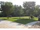 Well-maintained front yard with mature trees and a car in the driveway enhances the curb appeal at 14335 Saint Johns Dr # 83, Stanfield, NC 28163