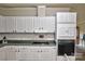 Functional kitchen with white cabinets, tile backsplash, green countertops, and modern appliances at 14335 Saint Johns Dr # 83, Stanfield, NC 28163