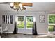 Bright living room featuring decorative artwork, windows and sheer curtains, ceiling fan and door leading to a porch at 14335 Saint Johns Dr # 83, Stanfield, NC 28163