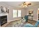 The cozy living room features a decorative fireplace and ceiling fan at 14335 Saint Johns Dr # 83, Stanfield, NC 28163
