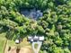 Aerial view of house nestled among lush trees including pond and outbuildings at 16132 Mclester Rd, Oakboro, NC 28129
