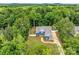 Stunning aerial view of a blue two-story home nestled in a lush green forest at 1622 Hunters Place Rd, York, SC 29745