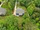 Aerial shot of a blue home with a long driveway surrounded by dense trees at 1622 Hunters Place Rd, York, SC 29745