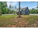 Lush backyard with mature trees and a white fence, providing privacy and a scenic view of the home's exterior at 1622 Hunters Place Rd, York, SC 29745