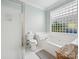 Bright bathroom featuring a shower, toilet, and tub with glass block window for natural light at 17732 Kings Point Dr, Cornelius, NC 28031