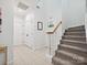 Bright foyer with tile flooring, staircase, coat closet, and horseshoe decor creating a welcoming entrance at 17732 Kings Point Dr, Cornelius, NC 28031