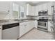Well-lit kitchen featuring stainless steel appliances, white cabinets, and granite countertops for a modern look at 17732 Kings Point Dr, Cornelius, NC 28031