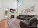 Spacious living room with fireplace, high ceilings, and large windows providing ample natural light at 17732 Kings Point Dr, Cornelius, NC 28031