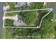 An aerial view of a home with lush landscaping, a driveway, and a waterfront backyard, outlined in white at 18118 Pompano Pl, Cornelius, NC 28031