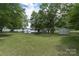 Expansive backyard with lush lawn, mature trees, storage shed, gazebo, and lake access at 18118 Pompano Pl, Cornelius, NC 28031