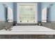 Inviting soaking tub beneath a window makes for the perfect place to unwind and relax at 18118 Pompano Pl, Cornelius, NC 28031