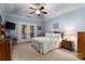 Bright primary bedroom with double doors, ceiling fan and neutral carpet at 18118 Pompano Pl, Cornelius, NC 28031