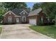 Charming brick home with manicured lawn, arched entryway, and a spacious driveway to a two car garage at 18118 Pompano Pl, Cornelius, NC 28031
