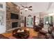 Comfortable living room featuring a stone fireplace, hardwood floors, and natural light from the French doors at 18118 Pompano Pl, Cornelius, NC 28031