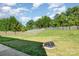 Large backyard with a fire pit, surrounded by a wooden fence and green grass at 1905 Yellow Daisy Dr, Matthews, NC 28104