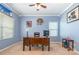 Well-lit bedroom with blue walls, large desk, and neutral carpeting providing a calm aesthetic at 1905 Yellow Daisy Dr, Matthews, NC 28104