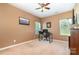 Bedroom with tan walls and carpet, two windows, and a desk area for functionality at 1905 Yellow Daisy Dr, Matthews, NC 28104