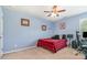 Cozy bedroom featuring red plaid bedding, ceiling fan, and a comfortable workspace at 1905 Yellow Daisy Dr, Matthews, NC 28104