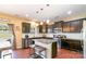 Kitchen featuring dark cabinets, stainless appliances, island with seating and access to the backyard at 1905 Yellow Daisy Dr, Matthews, NC 28104