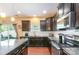 Well-lit kitchen features dark cabinets, stainless steel appliances, granite countertops and hardwood floors at 1905 Yellow Daisy Dr, Matthews, NC 28104