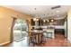 Well-lit kitchen featuring an island with seating, dark cabinetry, and a sliding glass door to the backyard at 1905 Yellow Daisy Dr, Matthews, NC 28104