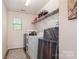Functional laundry room with washer, dryer, shelf for storage, and neutral flooring at 1905 Yellow Daisy Dr, Matthews, NC 28104