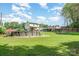 Spacious backyard with a pool, deck, fire pit, and lush lawn, ideal for outdoor entertaining and recreation at 205 Wingate Dr, Stanley, NC 28164