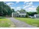Charming two-story home featuring a long driveway, lush lawn, and classic architectural style at 205 Wingate Dr, Stanley, NC 28164
