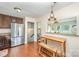Bright kitchen features stainless steel refrigerator, brown wood cabinets, and a dining nook with light fixture at 205 Wingate Dr, Stanley, NC 28164