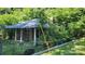 Quaint single-story home with front porch, surrounded by mature trees and greenery at 210 Mahan Sw St, Concord, NC 28025