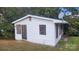 Exterior shot of a small, weathered home with boarded up windows and overgrown foliage at 210 Mahan Sw St, Concord, NC 28025