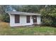 Exterior shot of a small, weathered home with boarded up windows and overgrown foliage at 210 Mahan Sw St, Concord, NC 28025