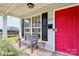 Inviting front porch with seating, a red door, and manicured plants adding to the curb appeal at 2117 Yadkin Ave, Charlotte, NC 28205