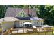 Backyard showcasing a large deck with outdoor seating, mature trees, and a lush, well-maintained lawn at 2168 Sunset Cir, Fort Mill, SC 29715