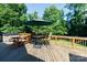 Picture of a wooden deck with a table, chairs, umbrella, hot tub, and picnic table overlooking the backyard at 2168 Sunset Cir, Fort Mill, SC 29715