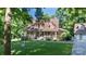 Traditional home with a wrap-around porch, American flag, mature trees, and a detached garage at 2168 Sunset Cir, Fort Mill, SC 29715