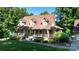 Charming home exterior featuring a welcoming porch, dormer windows, manicured lawn, and mature trees at 2168 Sunset Cir, Fort Mill, SC 29715