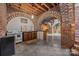 A finished basement with exposed brick archways and a partial kitchen setup at 217 S Ellis St, Salisbury, NC 28144